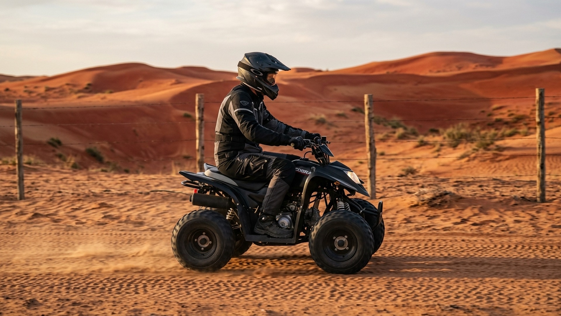 Quad rider wearing helmet and goggles on COBRA at Liwa Desert
