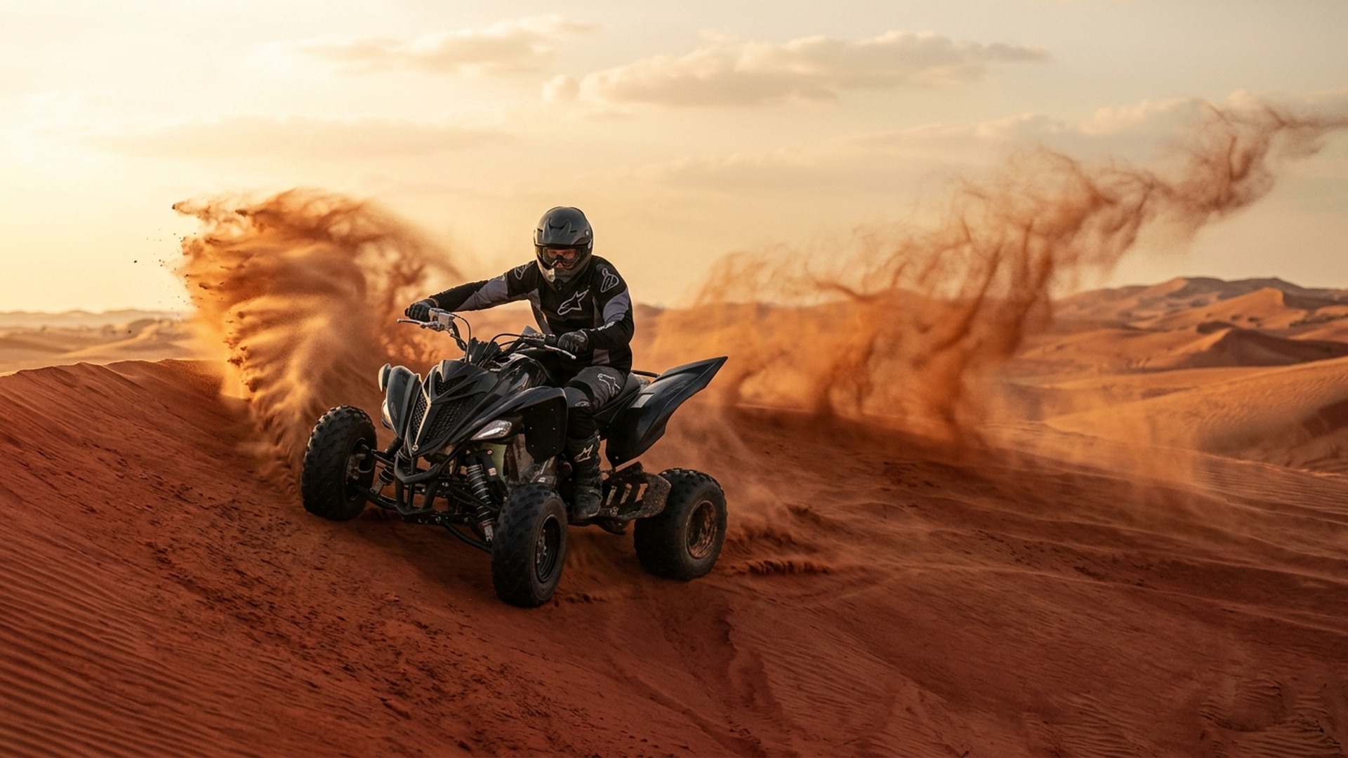 Sports quad making a fast controlled carve over a red dune